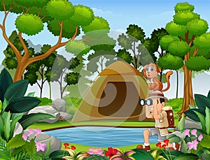 Boy using binoculars with a monkey near the small pond