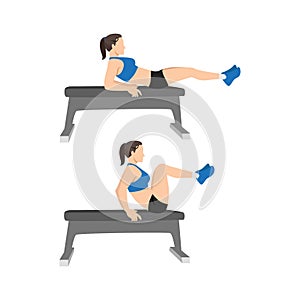 Woman doing Seated Bench leg pull ins. Flat bench knee ups exercise photo