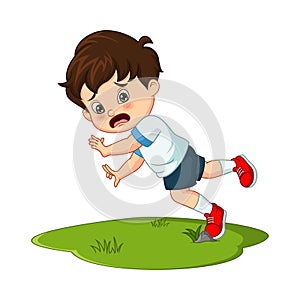 Cute little boy falling down in the grass