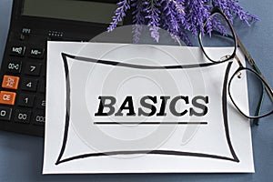 BASICS - word on a white sheet against the background of glasses, pens and lavender photo