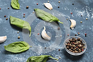 Basil Leaves, pepper and garlic on concrete background.