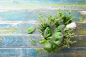 Basil, thyme, rosemary and tarragon. Aromatic herbs in mortar bowl on rustic wooden table top view. Fresh ingredients for cooking.