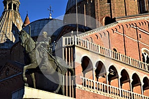 Basilica del Santo in Padua. Illuminated by the sun near sunset with the statue of Gattamelata on horseback in the foreground.