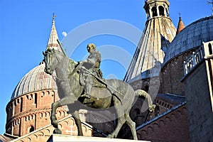 Basilica del Santo in Padua. Illuminated by the sun near sunset with the statue of Gattamelata on horseback in the foreground and