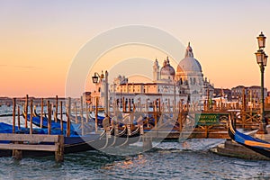 Basilica di Santa Maria della Salute and gondolas on the sea at sunrise / sunset time, Venice