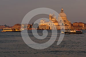 Basilica di Santa Maria della Salute at orange colors reflected on the water surface, Venice, Italy