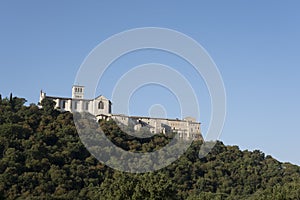 Basilica of St. Francis of Assisi, Basilica Papale di San Francesco, with statue at dawn in Assisi, Umbria, Italy