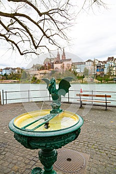 Basilisk fountain with view of Basel old Town and Rhine river, Switzerland