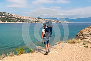 Baska - Father with baby carrier on hiking trail with panoramic aerial view of idyllic beach in coastal town Baska