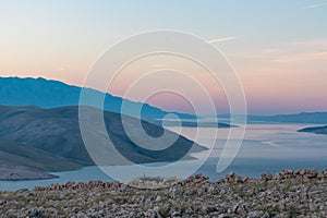 Baska - Panoramic sunrise view of deserted island Prvic seen from idyllic hiking trail near coastal town Baska