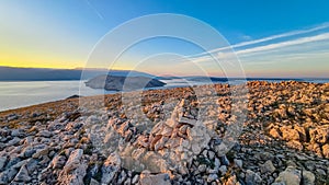 Baska - Panoramic sunrise view of deserted island Prvic seen from idyllic hiking trail near coastal town Baska