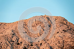 Baska - Panoramic view during sunrise of majestic mountains with massive rock formation in coastal town Baska, Krk Otok