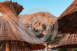 Baska - Straw umbrellas and loungers on idyllic pebble beach in resort town Baska, Krk Otok, Primorje-Gorski Kotar, Croatia