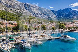 Baska Voda town with harbor against mountains in Makarska riviera, Dalmatia, Croatia