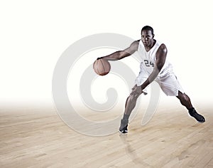 Basketball Player dribbling on a hardwood court photo