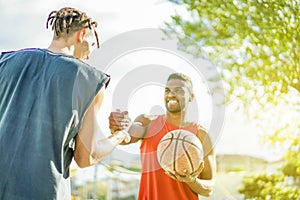 Baskeball players shakings hand before two on two game - Multiracial basket athletes showing respect clapping hand - Fair