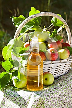 Basket with apples cider juice or vinegar in glass bottle