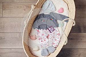 Basket with baby clothes. Wicker basket with baby stuff and accessories for newborn