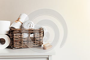 Basket with bathroom accessories. A set of rolled towels. Hotel cleaning concept