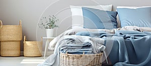 A basket of blue blankets and pillows on a bed