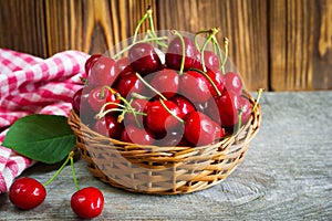 A basket with cherrys on wooden table photo