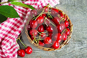 A basket with cherrys on wooden table photo
