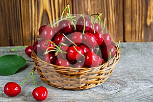 A basket with cherrys on wooden table