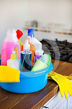 Basket with cleaning items on blurry background white citchen. C photo