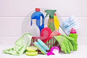 Basket with colored lips and rags, gloves and detergents in colored plastic bottles