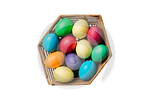 Basket of colorful Easter eggs isolated on white background. Easter basket filled with colored eggs top view holiday