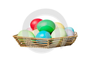 Basket of colorful Easter eggs isolated on white background. Easter basket filled with colored eggs top view holiday