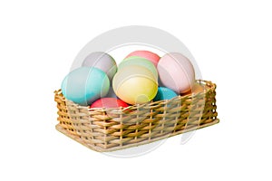 Basket of colorful Easter eggs isolated on white background. Easter basket filled with colored eggs top view holiday