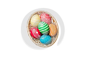 Basket of colorful Easter eggs isolated on white background. Easter basket filled with colored eggs top view holiday