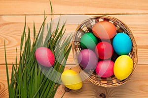 Basket with colorful Easter eggs and lush grass