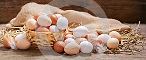 basket of colorful fresh eggs on wooden table