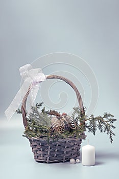 Basket with coniferous branches and Christmas ball in rustic style. Christmas decor made of ecological materials.