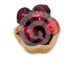 Basket of dark red apples on a white background