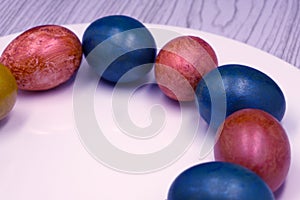 Basket with easter cake and red eggs on rustic wooden table. Top view.