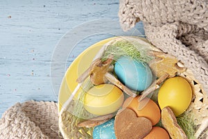 Basket with Easter colored eggs and cookies