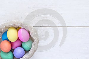 Basket with easter eggs on white background and copy space. Top
