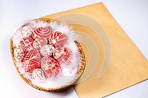 Basket with Easter red eggs with folk white pattern on sheet old paper left side