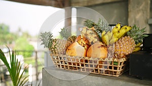 Basket with exotic fruit on a bar counter of an outdoor rooftop cafe. Laying out of tropical fruit in a restaurant to