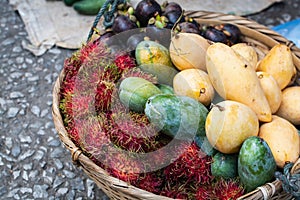 Basket with exotic fruits of mango, mangosteen and rambutan on Asian market