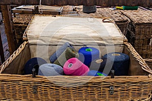 a basket filled with various colored yarn on a table next to other items