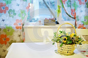 Basket of flowers and butterfly is on table in photo