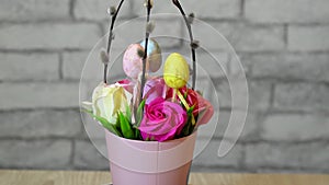 Basket with flowers, willow twigs and easter eggs in slowmo is spinning