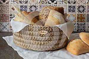 Basket with fresh bread on table in kitchen