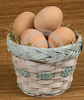 Basket of fresh eggs on a mottled background