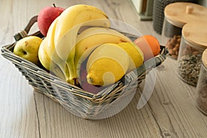 Basket with fresh fruits on table in kitchen