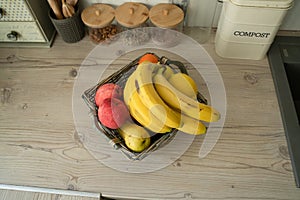 Basket with fresh fruits on table in kitchen